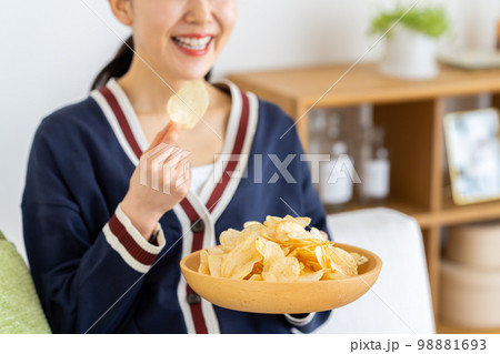 ポテトチップスを食べる若い女性 ポテトチップスを食べる若い女性 98881693