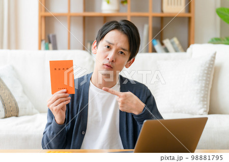 年金手帳を持って悩む男性 98881795