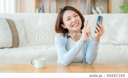 スマホを持つミドル女性 98882189