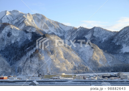 朝日に照らされた雪山と雪国の町 98882643