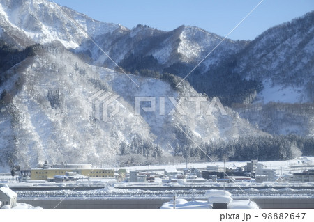 朝日に照らされた雪山と雪国の町 朝日に照らされた雪山と雪国の町 98882647