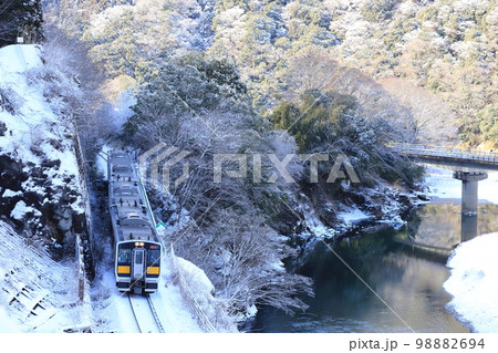 水郡線「雪化粧した山間部と久慈川沿いを走る列車」 98882694
