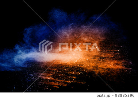 Orange blue powder explosion on black background.Orange blue color dust splashing. Orange blue powder explosion on black background.Orange blue color dust splashing. 98885396