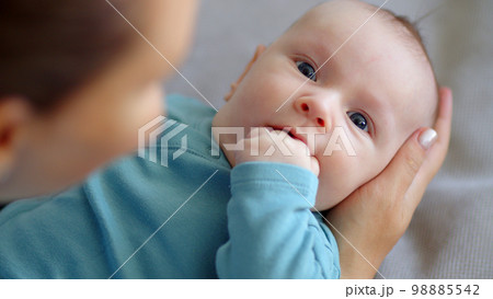 Newborn baby happy to looking on his mom . Happy mother spends time with her child. Mother playing with an infant kid.   Infant with blue eyes happy being with mama. Maternity and childcare concept. 98885542