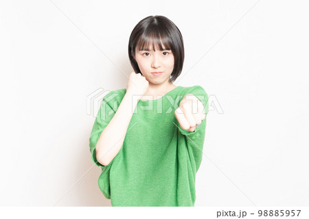 ボクシングのジェスチャーをする若い女性 ボクシングのジェスチャーをする若い女性 98885957