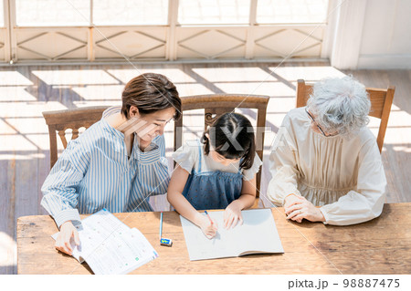 勉強する女の子と見守る家族 98887475