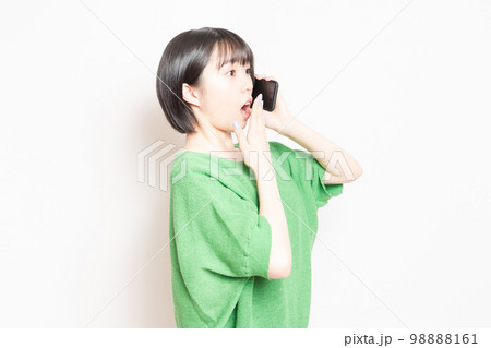 スマホを使いながら驚いている若い女性 98888161