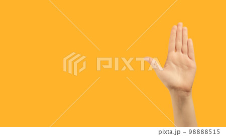 Stop gesture. No sign. Restriction rejection. Raised female hand palm warning with nope enough signal on orange copy space background. 98888515