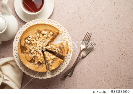 Caramel cheesecake served with cup of tea, top view. Copy space 98888600
