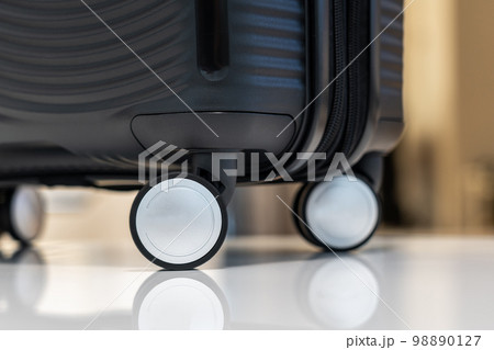 Close-up of black plastic travel carry-on suitcase on wheels Close-up of black plastic travel carry-on suitcase on wheels 98890127