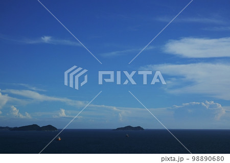 海に浮かぶ孤島と水平線の遠方に積乱雲が湧き上がる午後の風景・夏・220727pm 98890680