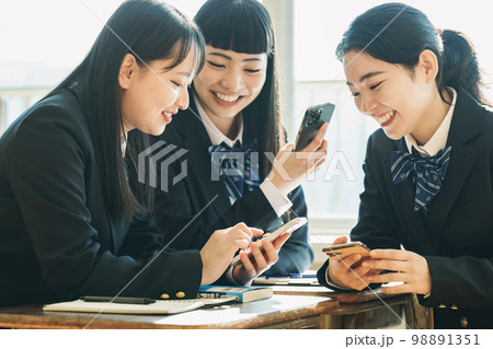 学校の教室でスマホを使う女子高生 98891351