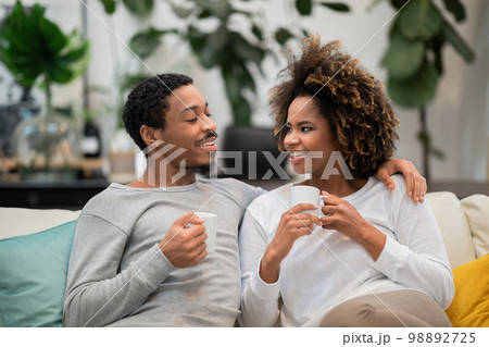 Beautiful african american couple drinking coffee at home 98892725