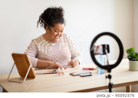 Pretty overweight lady makeup artist recording video while doing manicure Pretty overweight lady makeup artist recording video while doing manicure 98892876