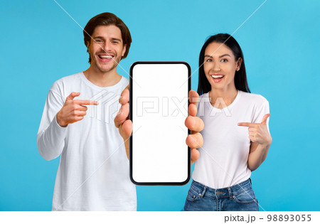 Check This. Happy couple pointing at smartphone with white blank screen 98893055