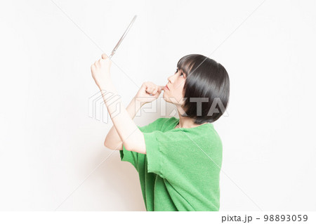 手鏡で顔を見ている若い女性 手鏡で顔を見ている若い女性 98893059