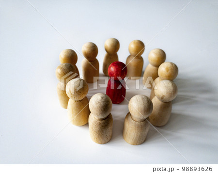 Red wooden doll figure surrounded by other doll figure on white background. Harassment and bully concept. Red wooden doll figure surrounded by other doll figure on white background. Harassment and bully concept. 98893626