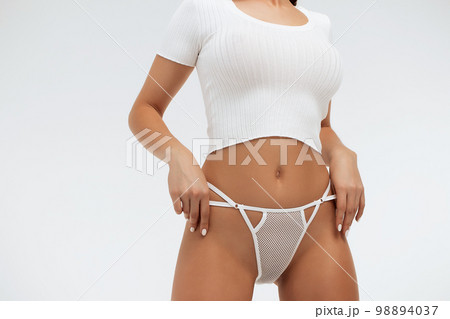 Faceless gorgeous woman with hands on thighs posing in studio Faceless gorgeous woman with hands on thighs posing in studio 98894037