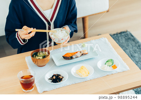 リビングで朝ごはんを食べる若い女性 リビングで朝ごはんを食べる若い女性 98895244