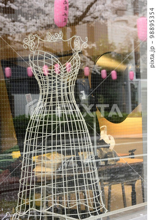 桜満開の商店街で軽やかな白いアートが飾られていた 98895354