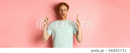 Portrait of surprised guy checking out advertisement, gasping amazed and pointing fingers up, showing promo, standing over pink background Portrait of surprised guy checking out advertisement, gasping amazed and pointing fingers up, showing promo, standing over pink background 98895731