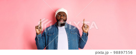 Disappointed and upset Black man frowning, pointing fingers up and staring at camera bothered, complaining at something, standing over pink background Disappointed and upset Black man frowning, pointing fingers up and staring at camera bothered, complaining at something, standing over pink background 98897556