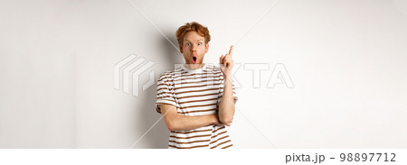 Excited redhead man having revalation, raising finger in eureka sign and saying idea, standing over white background 98897712