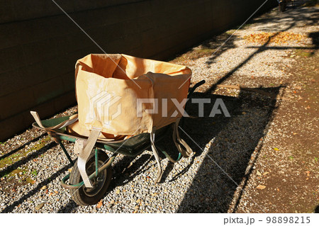 落ち葉掃除仕様の一輪車（作業用ネコ一輪車）：西日の街路にて 98898215