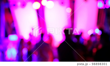 Blurred silhouettes of crowd of people dancing on the dance floor of a night club under the light of colored spotlights and lasers. Blurred silhouettes of crowd of people dancing on the dance floor of a night club under the light of colored spotlights and lasers. 98898301