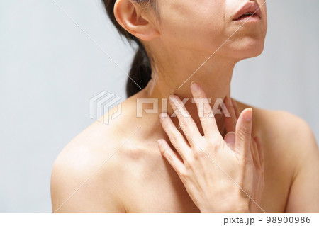 首元に手をやる中年女性 98900986