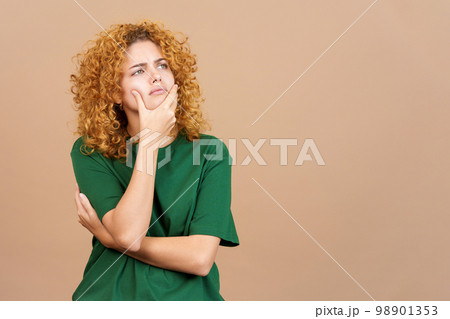 Woman gesturing and looking up with doubtful expression Woman gesturing and looking up with doubtful expression 98901353