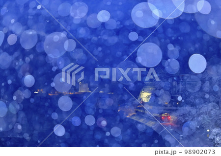 雪降る冬の氷見線（走り去る列車を後方から撮影） 98902073