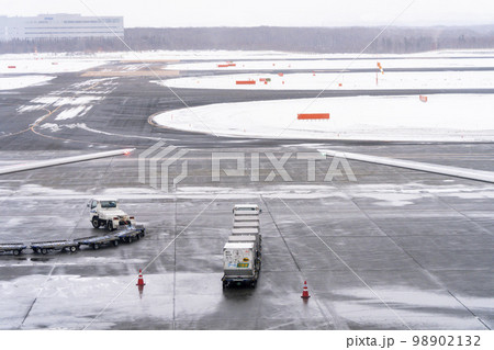 冬の空港の風景 待機するトーイングトラクターとコンテナ 新千歳空港 冬の空港の風景 待機するトーイングトラクターとコンテナ 新千歳空港 98902132
