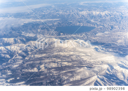 岩手上空から撮影した冬の田沢湖と羽後朝日岳の山並み 空撮 岩手上空から撮影した冬の田沢湖と羽後朝日岳の山並み 空撮 98902398