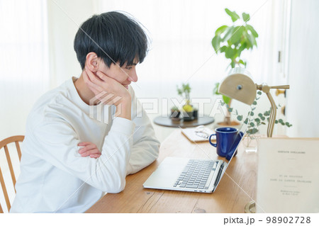 笑顔でパソコンを眺める男性 98902728
