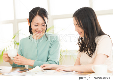 パンフレットを見ながら相談する二人の女性 98903654
