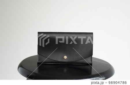 Wallet made of genuine black leather with a slots for cards and big zip pocket on a white background. Accessories for men. Wallet made of genuine black leather with a slots for cards and big zip pocket on a white background. Accessories for men. 98904786