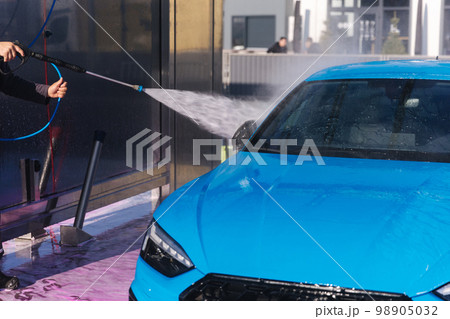 Worker cleaning car using high pressure water. Self servise car washing. Clean auto Worker cleaning car using high pressure water. Self servise car washing. Clean auto 98905032