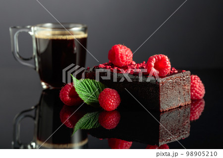 Chocolate cake with fresh raspberries and black coffee. Chocolate cake with fresh raspberries and black coffee. 98905210