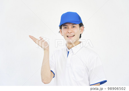 左を手のひらで指すポロシャツとキャップのユニフォームの男性　（引越し業者・運送業・作業員・宅配業者） 98906502
