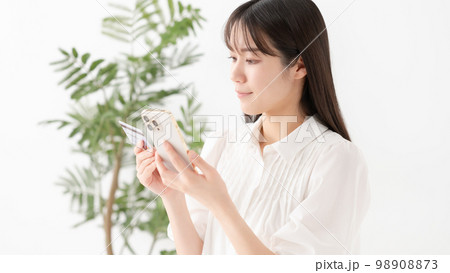 スマートフォンとカードを持つ女性 スマートフォンとカードを持つ女性 98908873