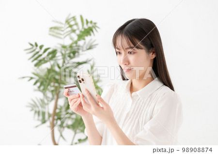 スマートフォンとカードを持つ女性 98908874