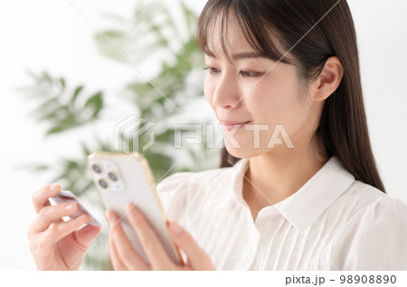 スマートフォンとカードを持つ女性 98908890