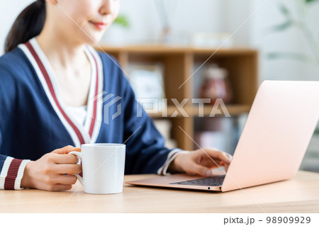 コーヒーを飲みながらパソコンを使う若い女性 コーヒーを飲みながらパソコンを使う若い女性 98909929