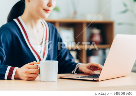コーヒーを飲みながらパソコンを使う若い女性 コーヒーを飲みながらパソコンを使う若い女性 98909930