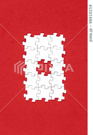 White puzzles on a red background, flat lay. White puzzles on a red background, flat lay. 98910259