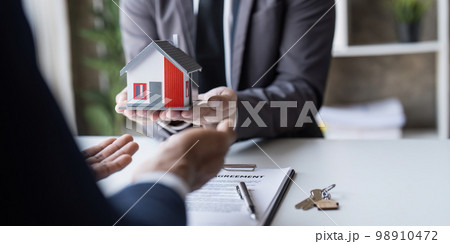 The house selling broker holds the keys and the model house is given to the customers,Real estate concept. The house selling broker holds the keys and the model house is given to the customers,Real estate concept. 98910472