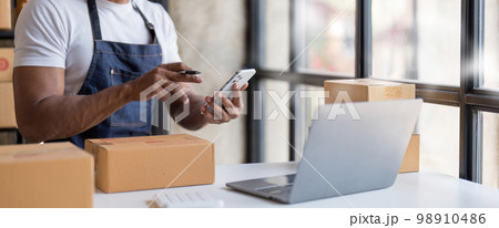 Starting small businesses SME owners man entrepreneurs Write the address on receipt box and check online orders to prepare to pack the boxes, sell to customers, sme business ideas online. 98910486