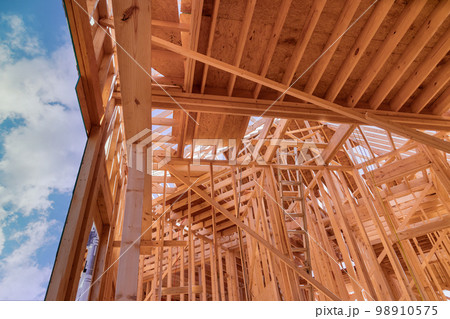 Newly constructed stick house will require constructing wooden roof rafters timber beams from framework trusses Newly constructed stick house will require constructing wooden roof rafters timber beams from framework trusses 98910575