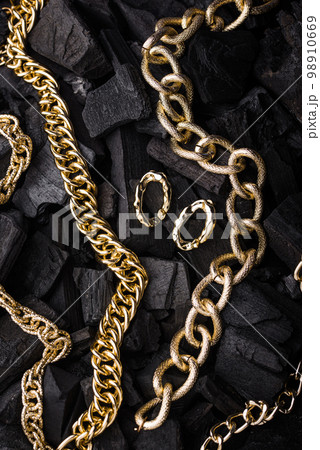 Golden chains earrings on black background. 98910669